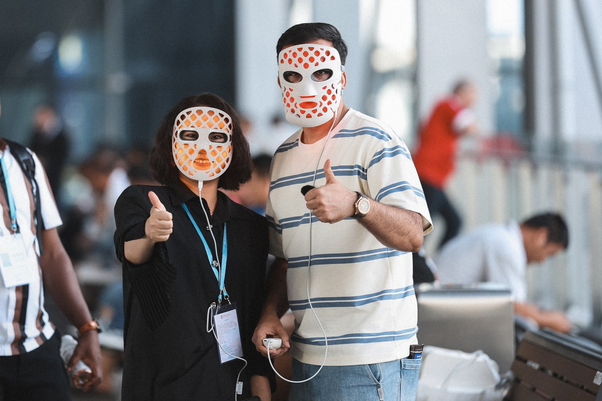 International Clients Testing Red Light Therapy Mask At Trade Show.jpg